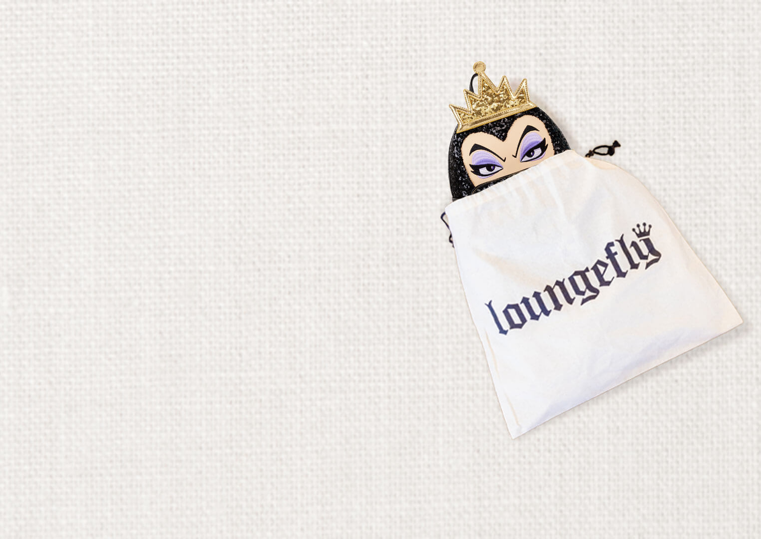 Gray white fabric background with Loungefly dust bag and Disney Maleficent mini backpack. Click to join the FanReward club!