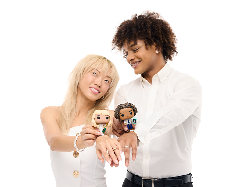 A couple dresses in wedding outfits holding up Funko Pop Yourself collectibles which look like them