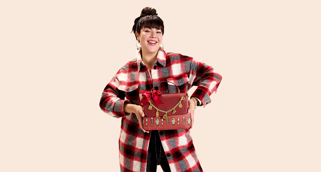 Solid colored Tan background with model showcasing Loungefly Home Alone accessories