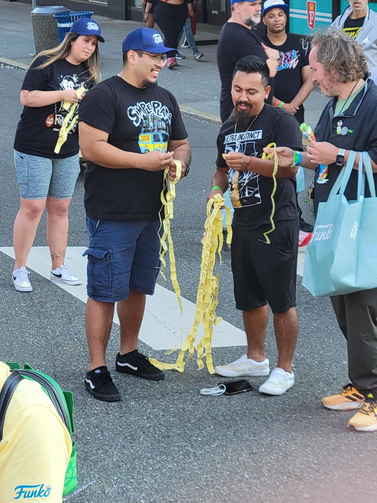 Tickets, Please! Funatics compare long reams of raffle tickets.