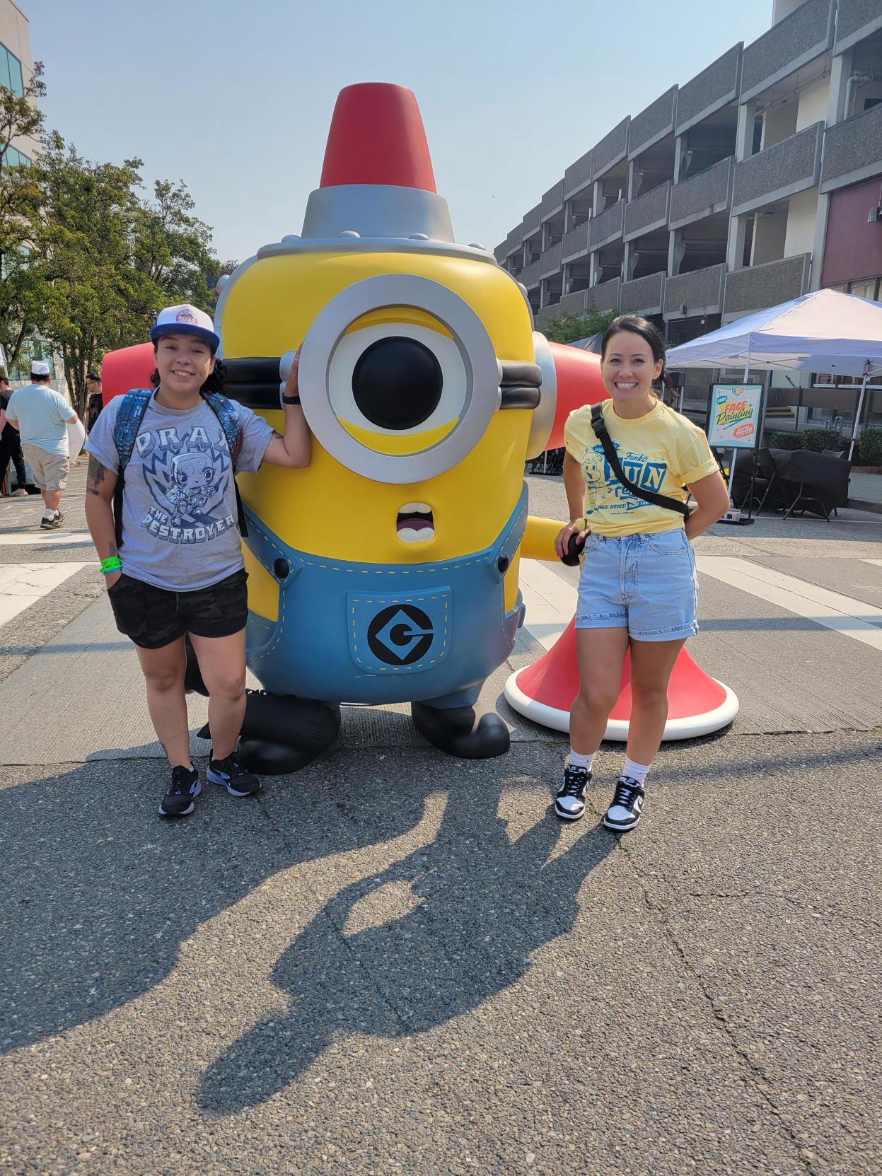 Minion Statue: Two Funko volunteers stand in front of the Minion statue.