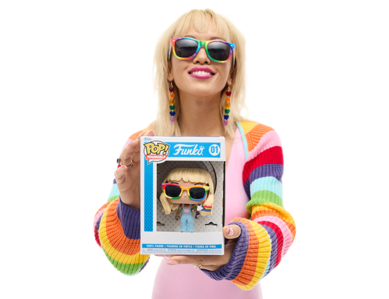 Model wearing rainbow accessories and apparel holding a Funko Pop! Yourself with pride accessories