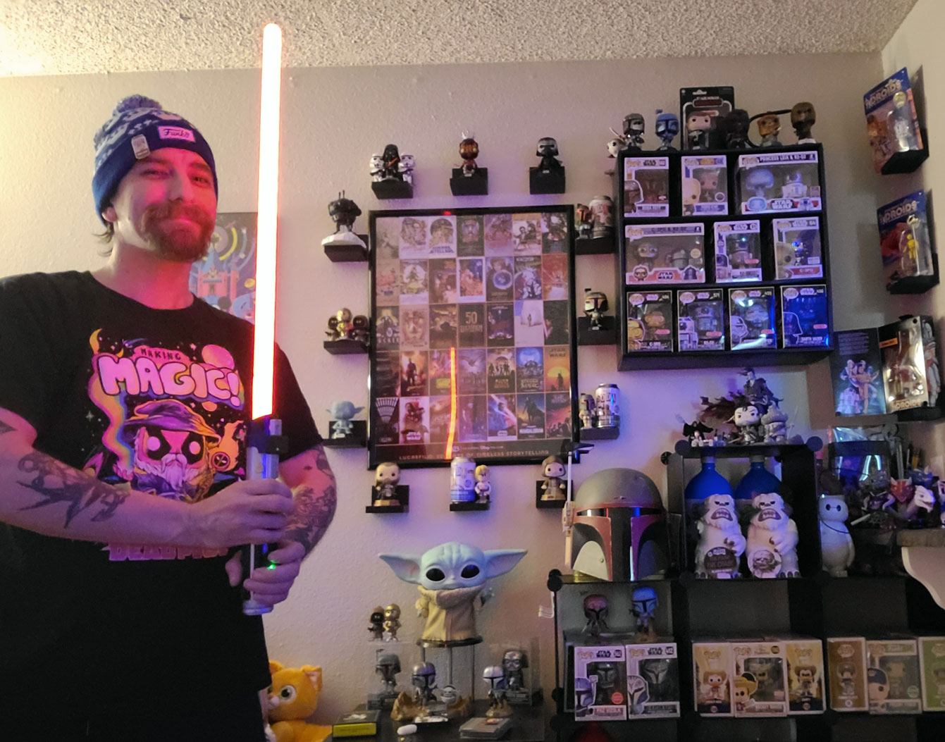 Garret brandishes a lightsaber in front of his Star Wars collection
