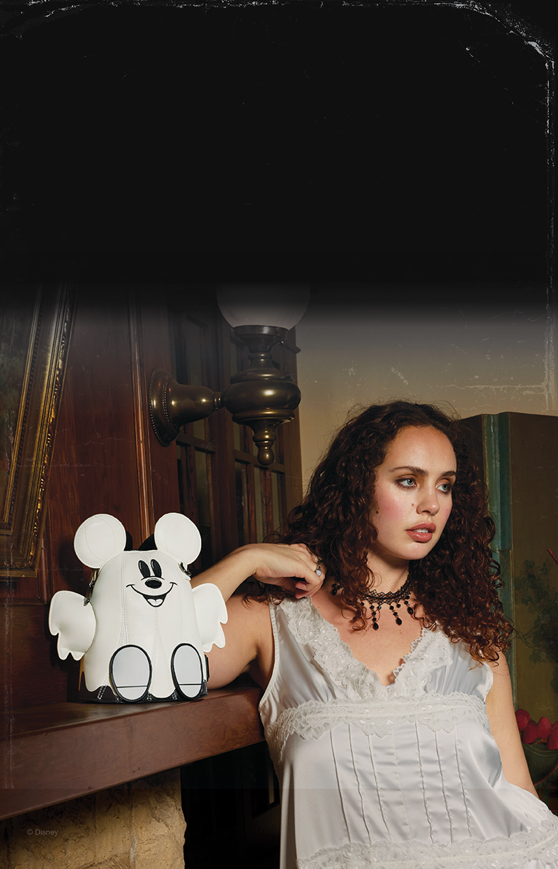 Dark old house background with model showcasing Loungefly Disney Halloween product