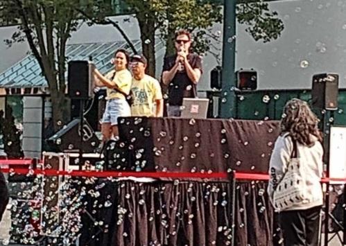 Music! The DJ stage is all set up, with bubbles floating all around. Volunteers on stage grab microphones to get the party started.