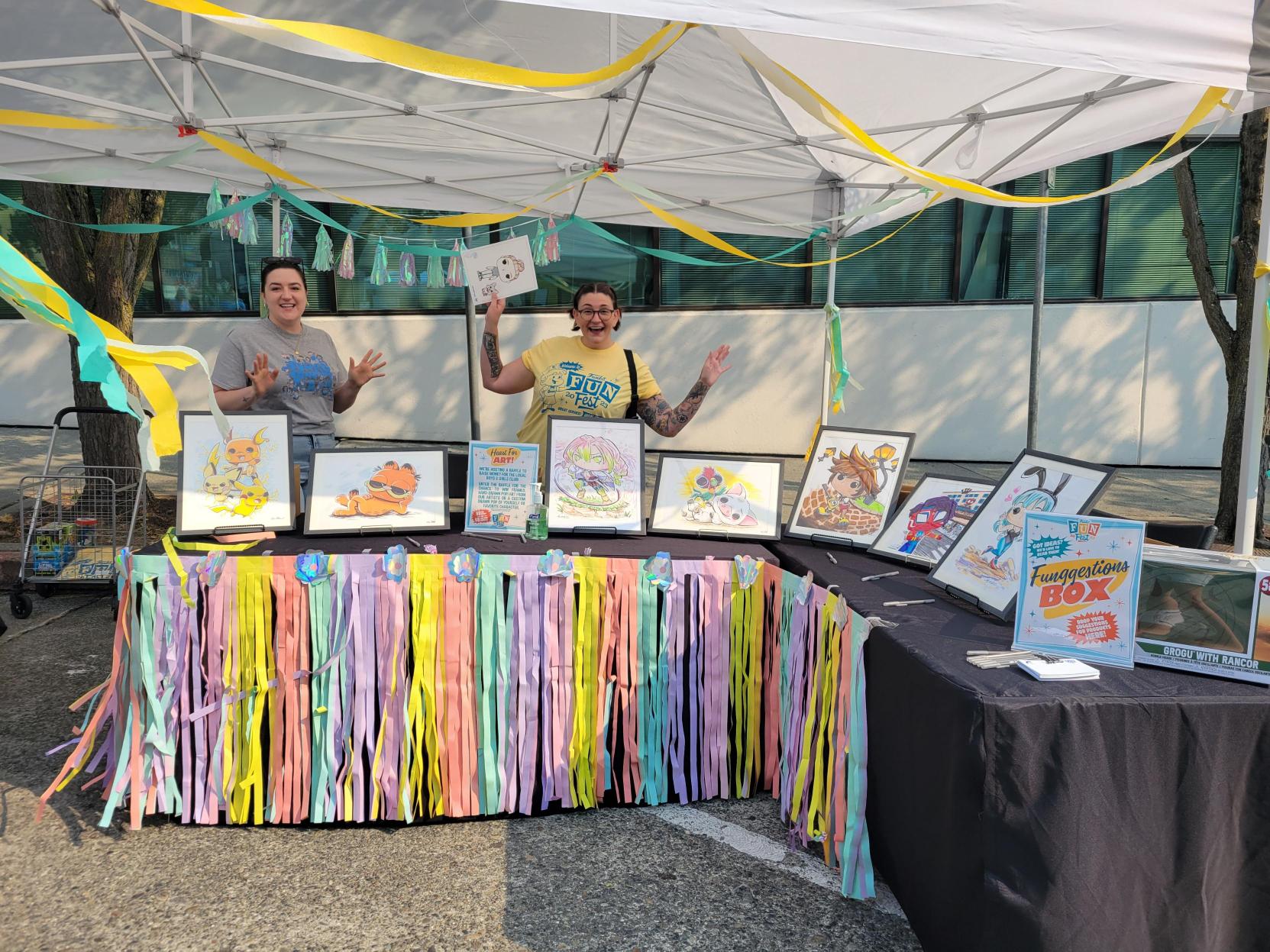 Art Tent: Funko volunteers staff the art raffle tent, decorated with colorful streamers and pictures of characters drawn by Funko artists. 